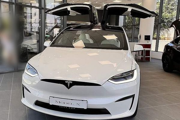 White Tesla Model X with its falcon-wing doors open